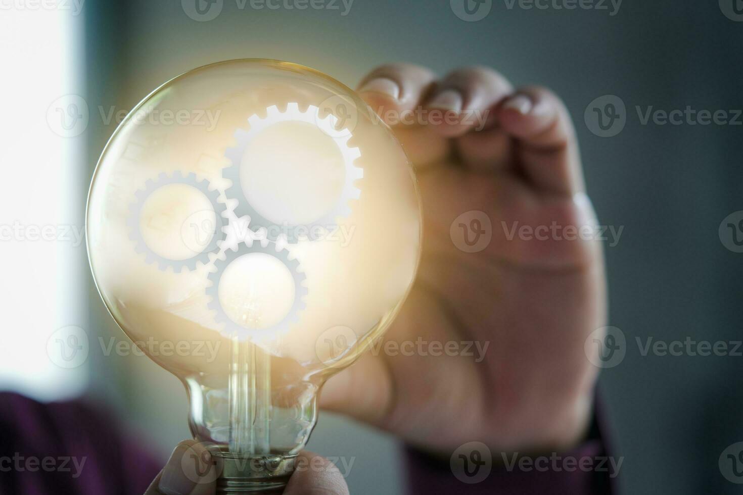 Glowing glass lightbulb with multiple gears inside photo