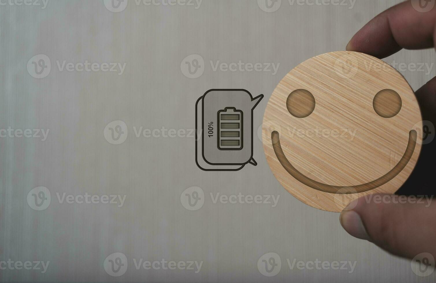Hands showing smile symbols on a wood block full of battery symbols. Positive concepts on mental health photo