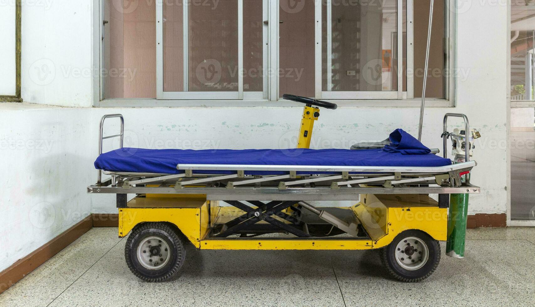 Wheelchair EV, equipped with bed and oxygen tank for transporting patients within the hospital building photo