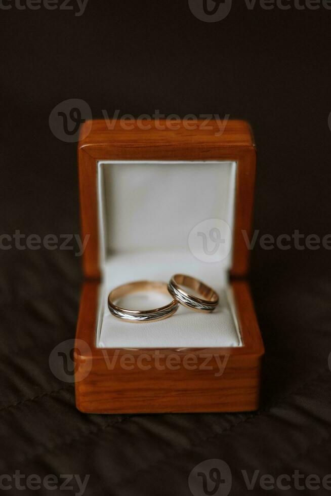 Close-Up Of Wedding Rings In Box On Table. wedding rings. Two golden wedding rings in a wooden box on a soft pillow. photo