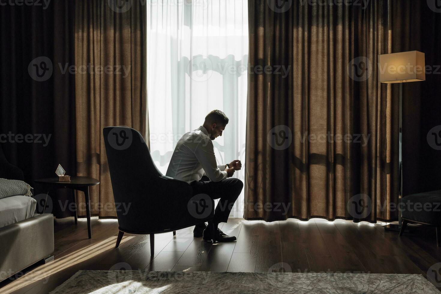 The stylish bridegroom dresses, prepares for the wedding ceremony. Wonderful interior in the morning light. The groom's morning photo