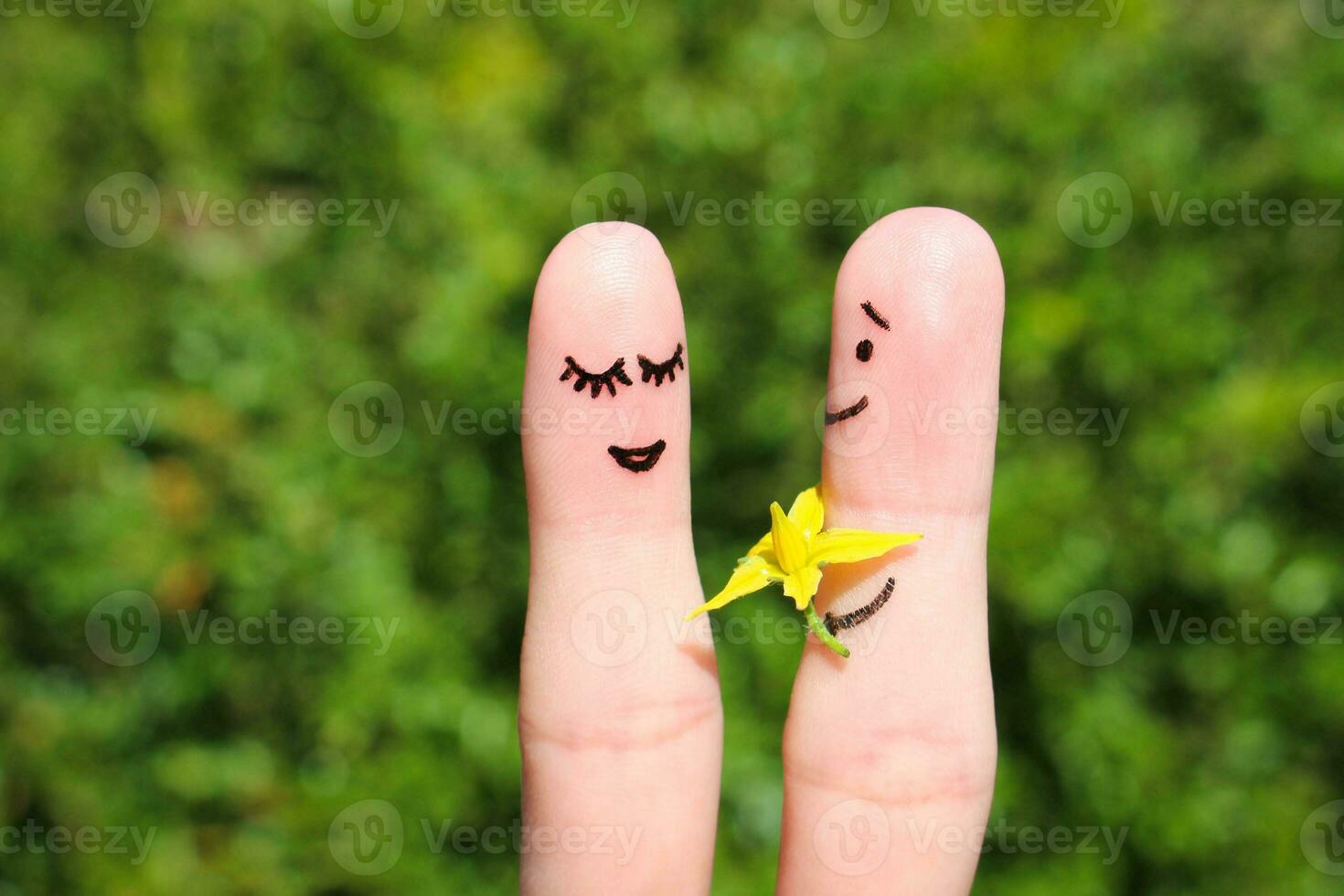 cara pintado en dedos. hombre es dando flores a un mujer. foto