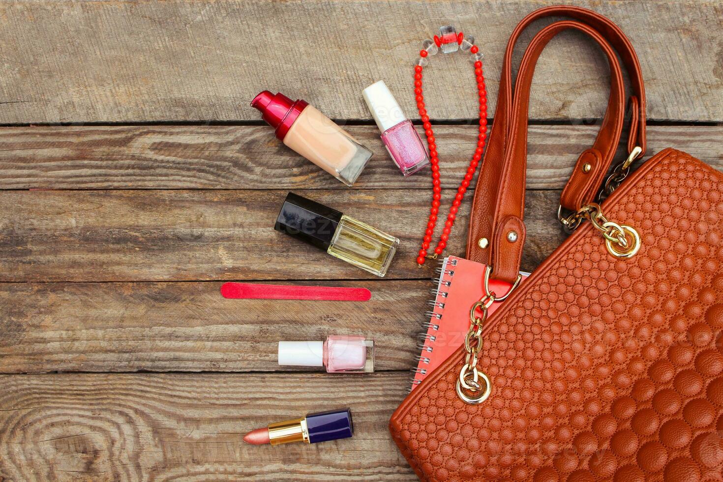 Things from open lady handbag. women's purse on wood background. Toned image. photo