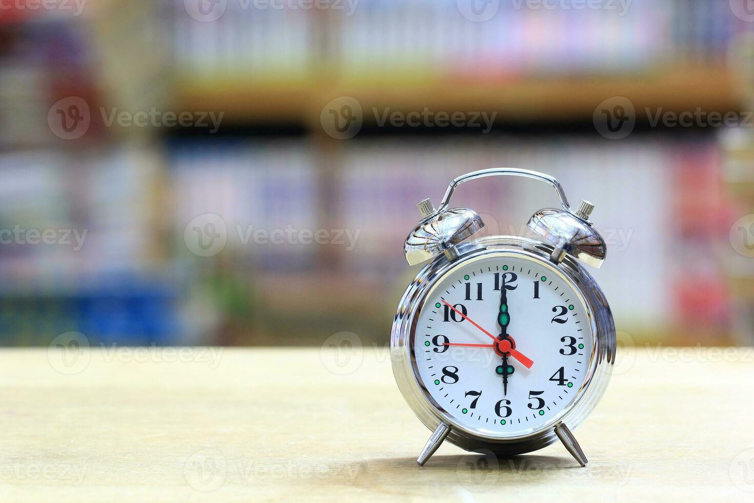 Alarm clock on bookshelf in the library room background photo