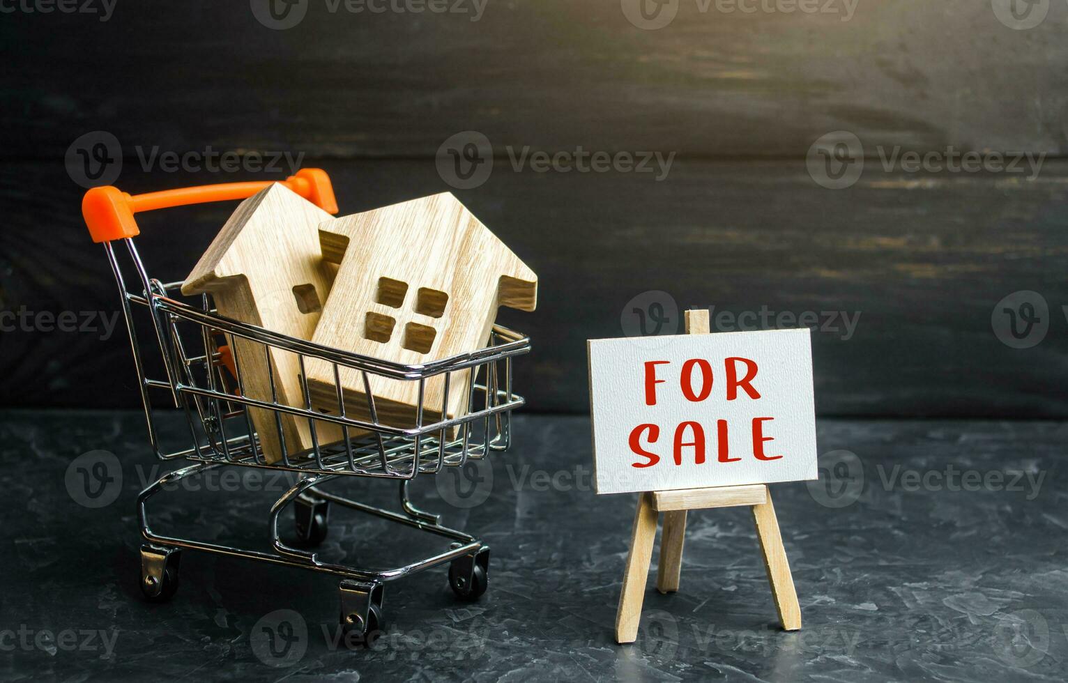 Shopping cart loaded with houses and sign for sale. Buying and selling housing. Saving money in real estate, investing in housing. Property appraisal. Secondary realty market. Attractive prices. photo
