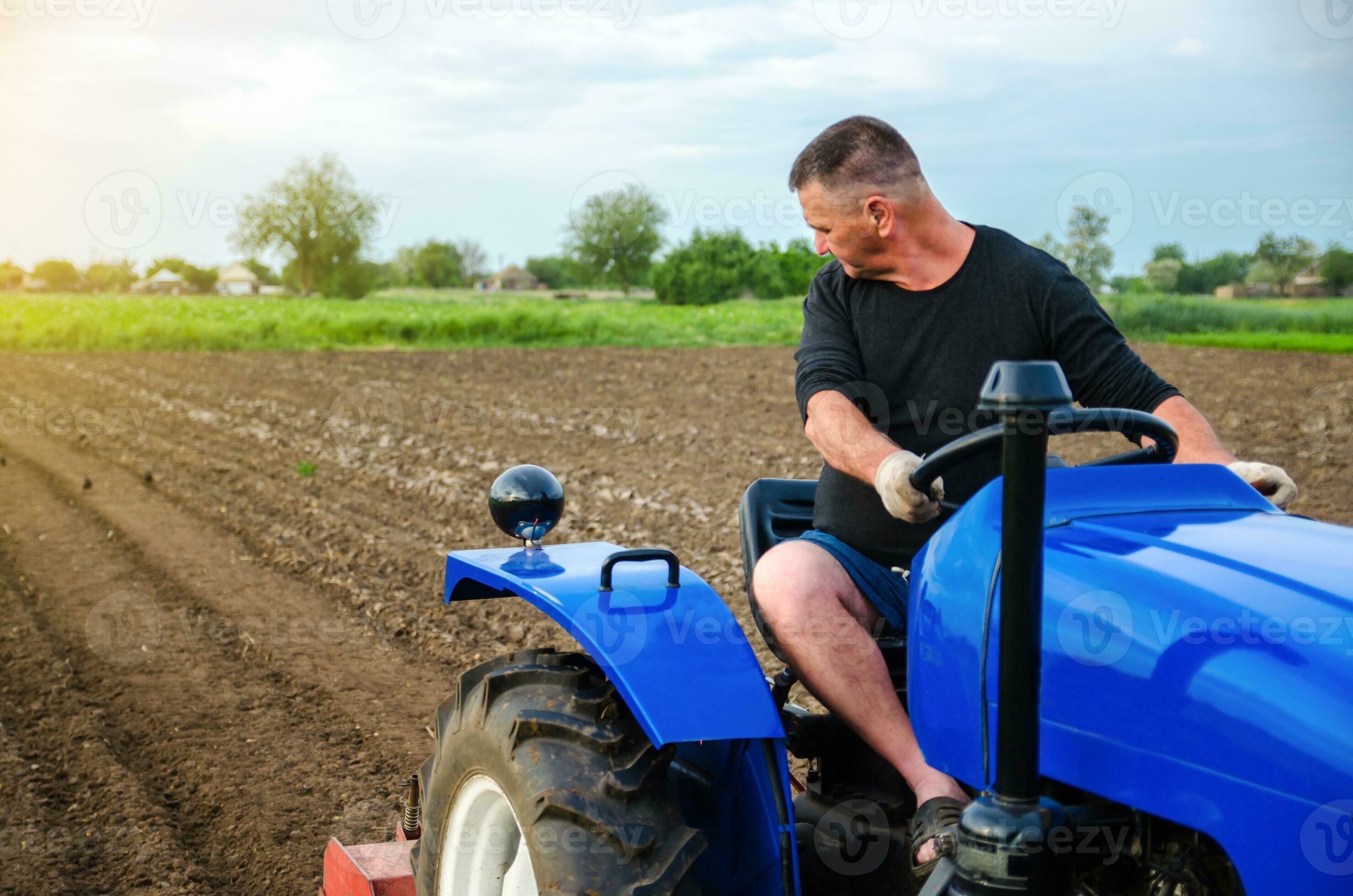 A farmer on a tractor works in the field. Freeing milling earth ground