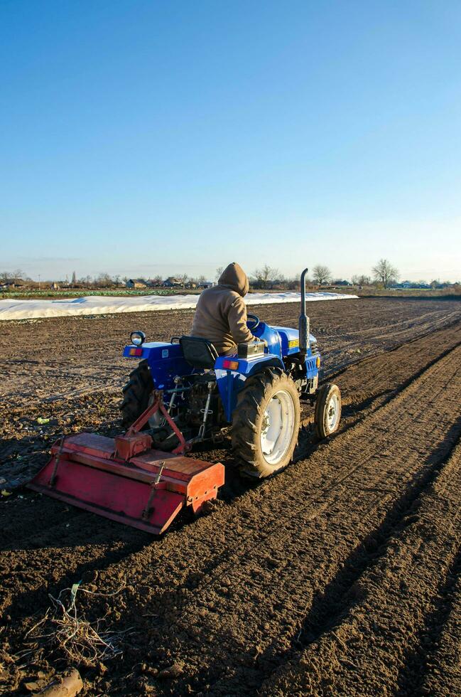 kherson oblast, Ucrania - noviembre 12, 2021 granjero es cultivando el granja campo. estacional obrero. reclutamiento trabajadores para conducción en agrícola maquinaria. tierra cultivo. agricultura. pequeño granjas foto