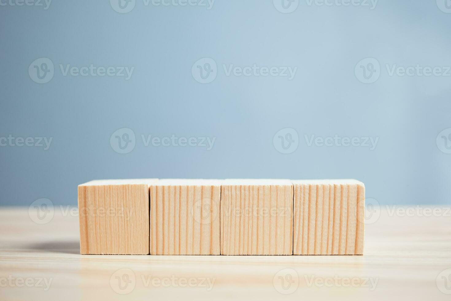 wood empty four blocks on table and blue blackground with copy space for text or symbols, development concept for growth success process. photo