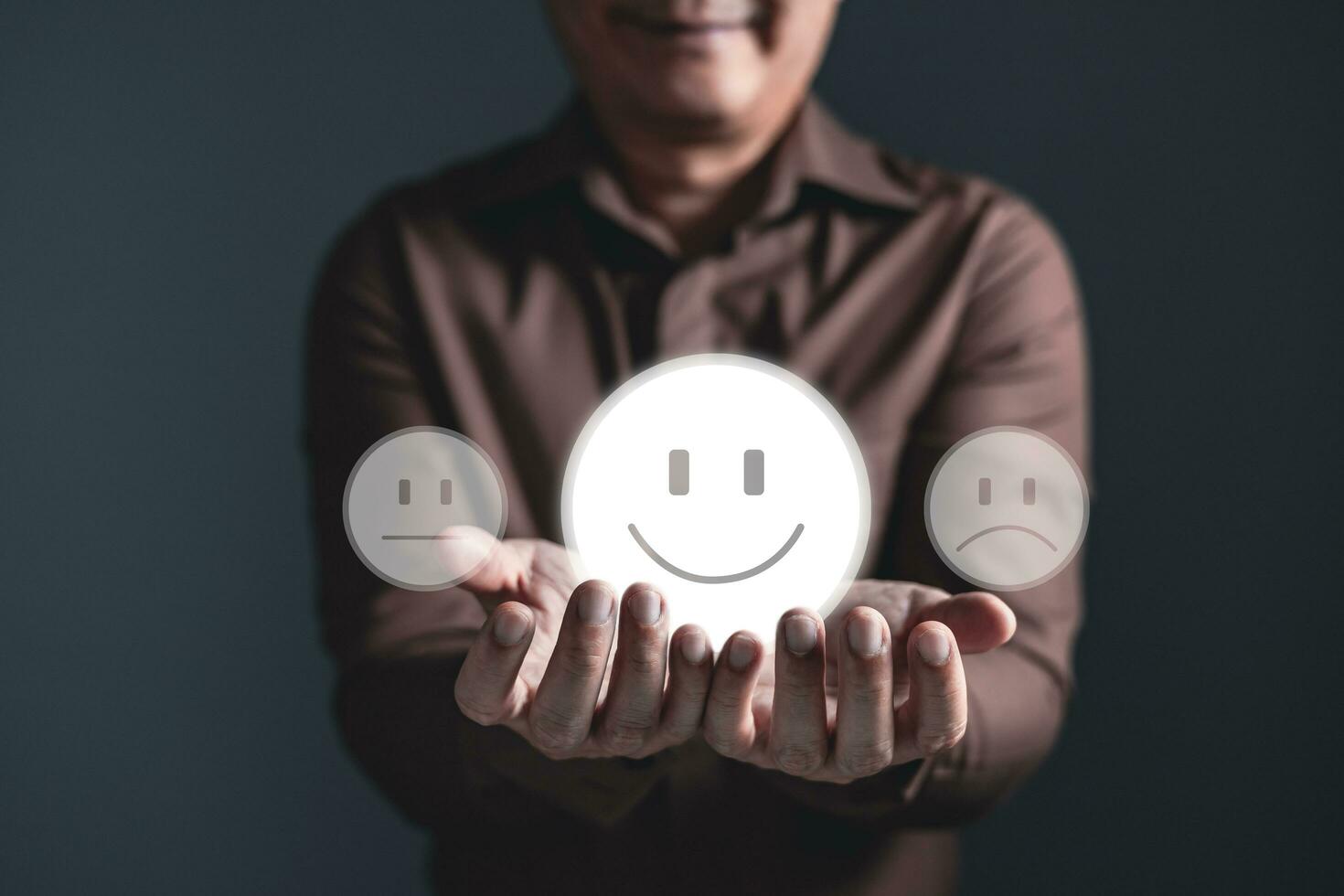 a businessman holding the virtual screen on the happy smile face icon to give satisfaction in service.rating very impressed.Customer service and Satisfaction concept. photo