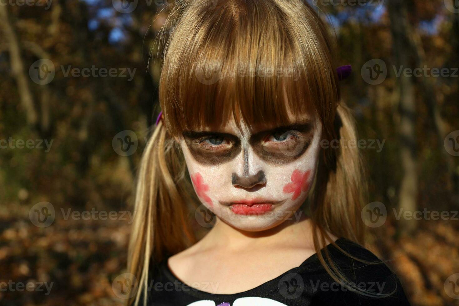 Portrait of little girl with sugar skull makeup of Calavera Catrina. Masquerade costume and painted face for Day of Dead, Dia de los Muertos. Halloween skeleton character, creepy angry zombie. photo