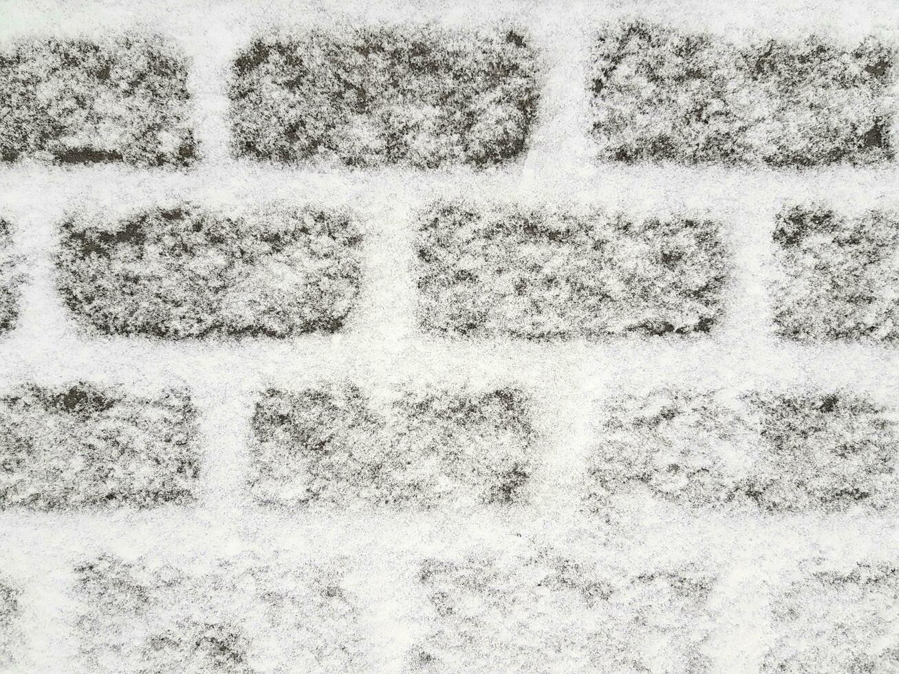 Snow covered dark grey sidewalk made of rectangular paving stones. Winter street background. Place for your text here photo