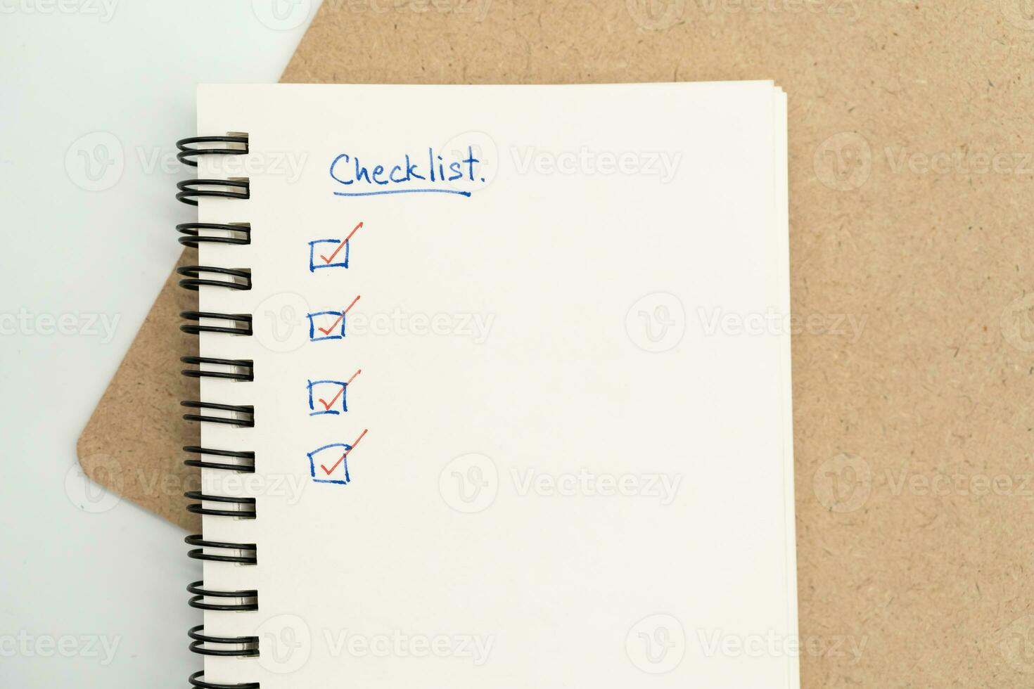Top view of notebook with handwritten Checklist text. Checklist concept, checklist box with red checkmark. photo