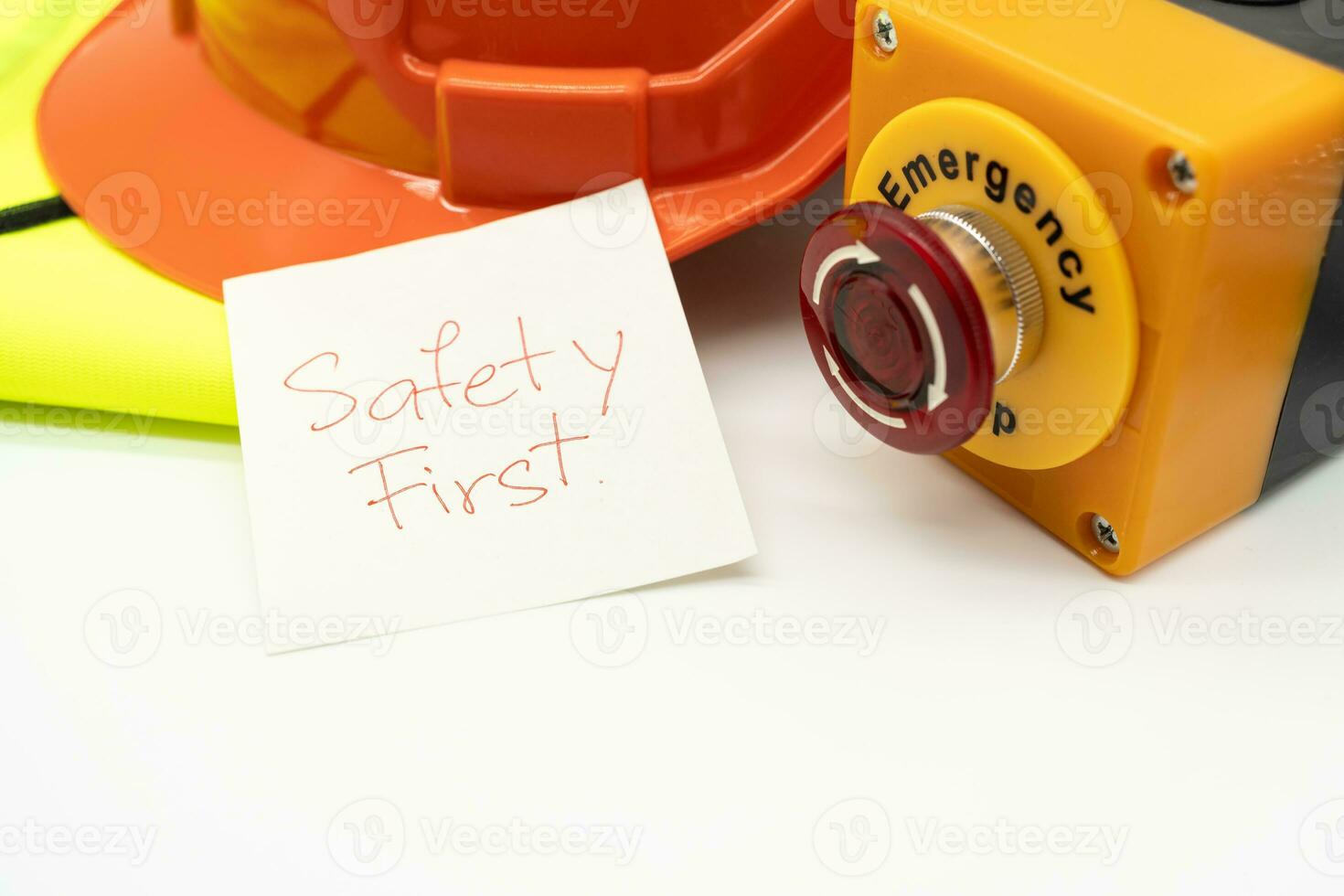 Safety First message on paper. Safety Gear. Reflective vest, safety hat or helmet and Emergency Stop Button. Safety First Concept. photo