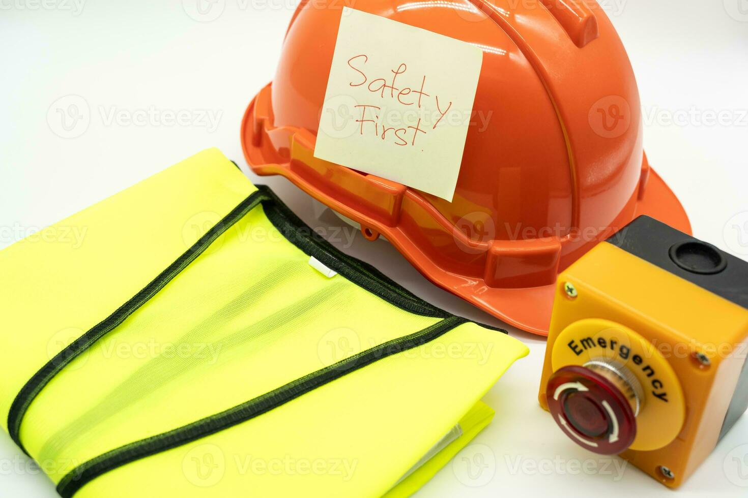 Safety First message on paper. Safety Gear. Reflective vest, safety hat or helmet and Emergency Stop Button. Safety First Concept. photo