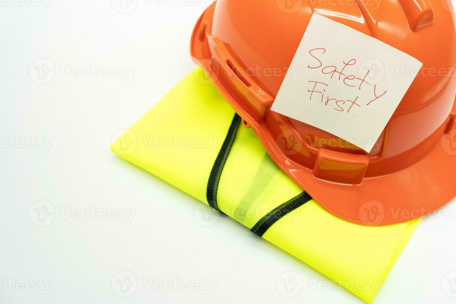 Safety First message on paper. Safety Gear. Reflective vest and safety hat or helmet. Safety First Concept. photo