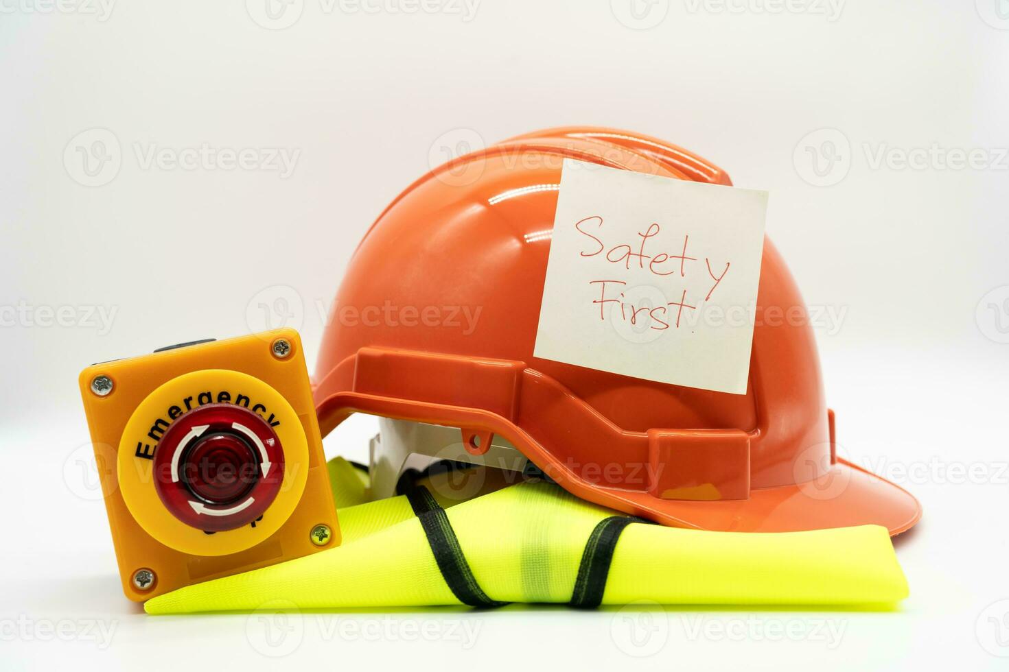 Safety First message on paper. Safety Gear. Reflective vest, safety hat or helmet and Emergency Stop Button. Safety First Concept. photo