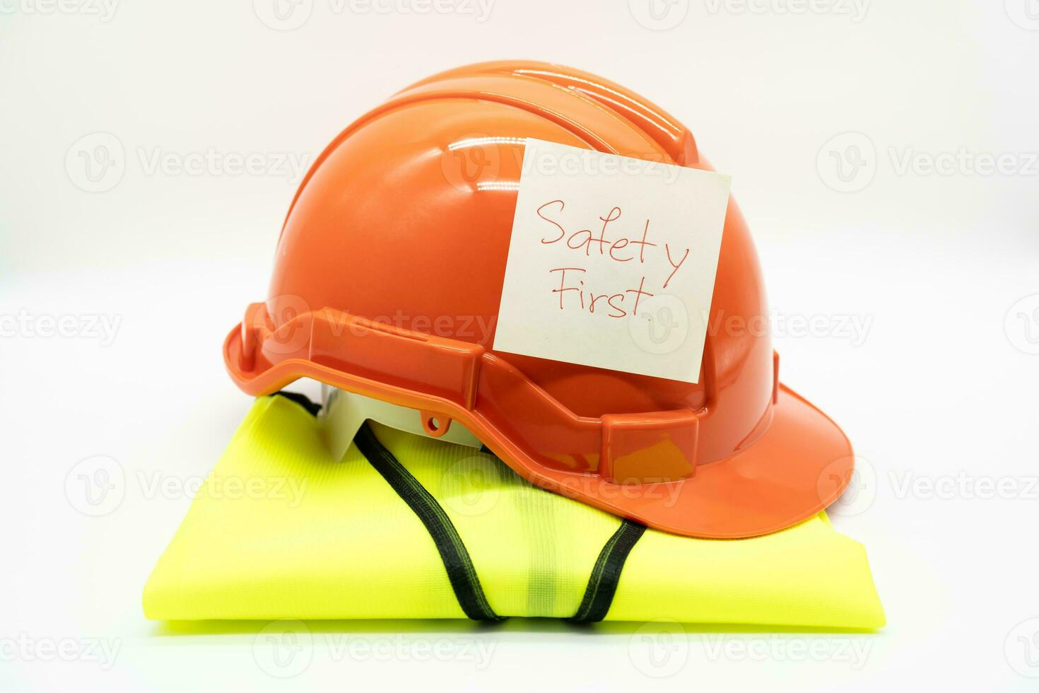 Safety First message on paper. Safety Gear. Reflective vest and safety hat or helmet. Safety First Concept. photo