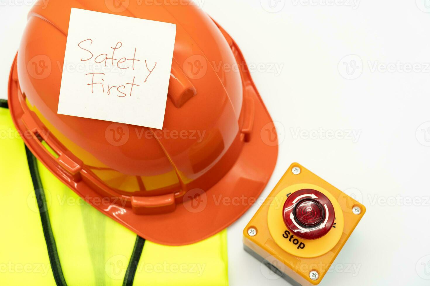 Safety First message on paper. Safety Gear. Reflective vest, safety hat or helmet and Emergency Stop Button. Safety First Concept. photo