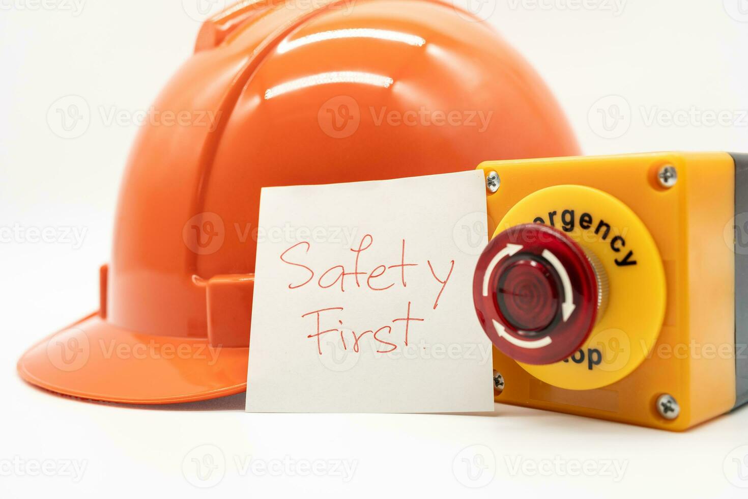 Orange safety hat with message Safety First and Emergency Stop Button isolated on white background. Safety First Concept. photo