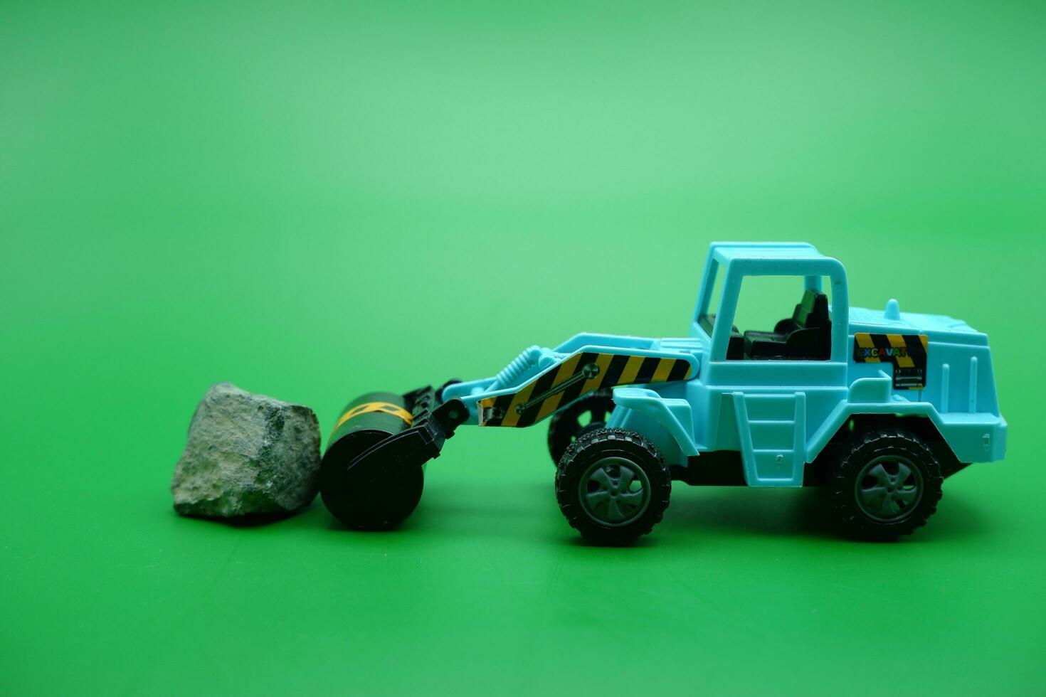 tandem roller toy in blue color isolated on green background. tandem rollers pushing rocks. photo