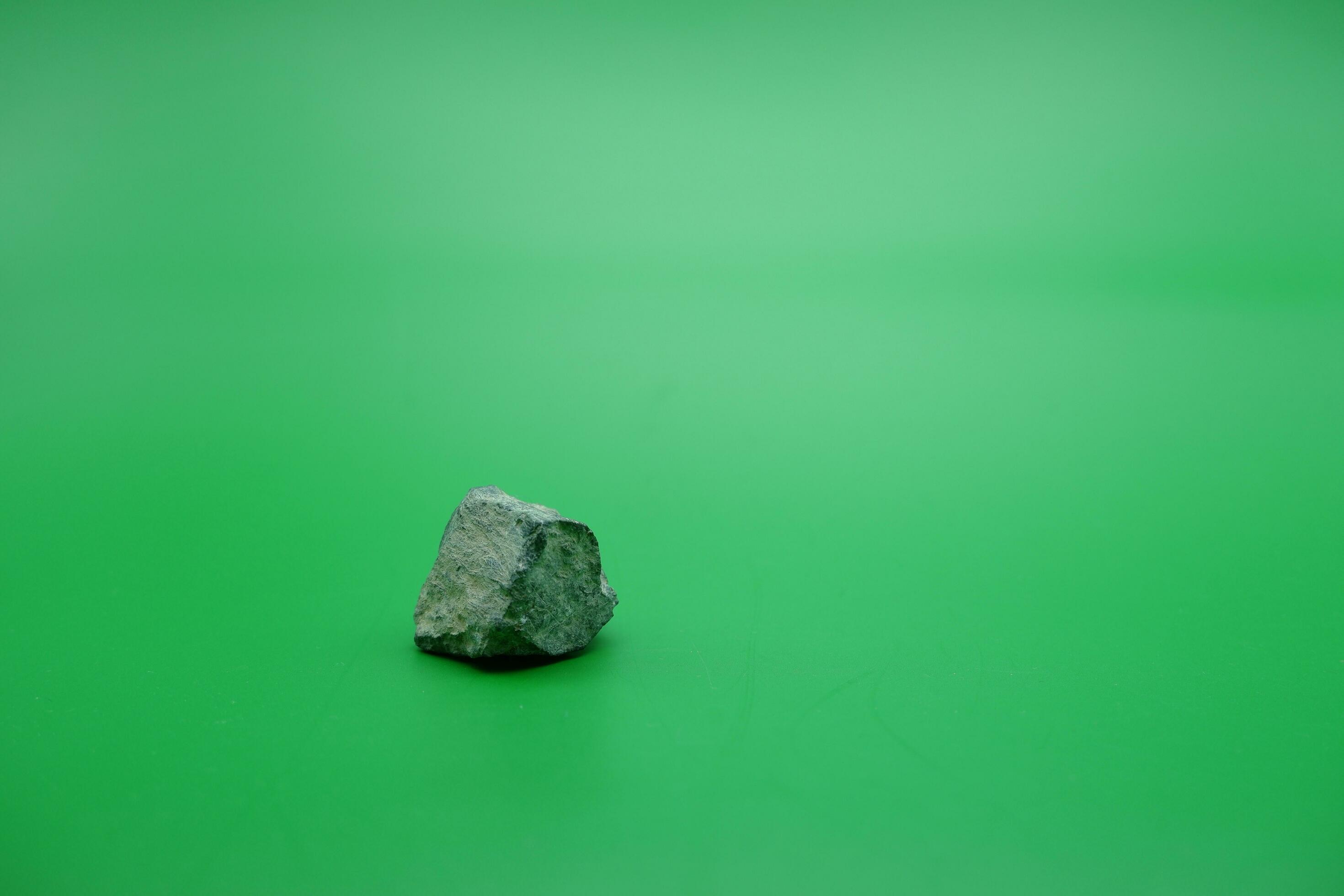 a-small-stone-isolated-green-background-stone-used-for-building