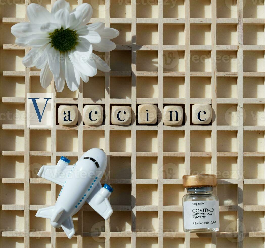 vaccine and a flower on a wooden table photo