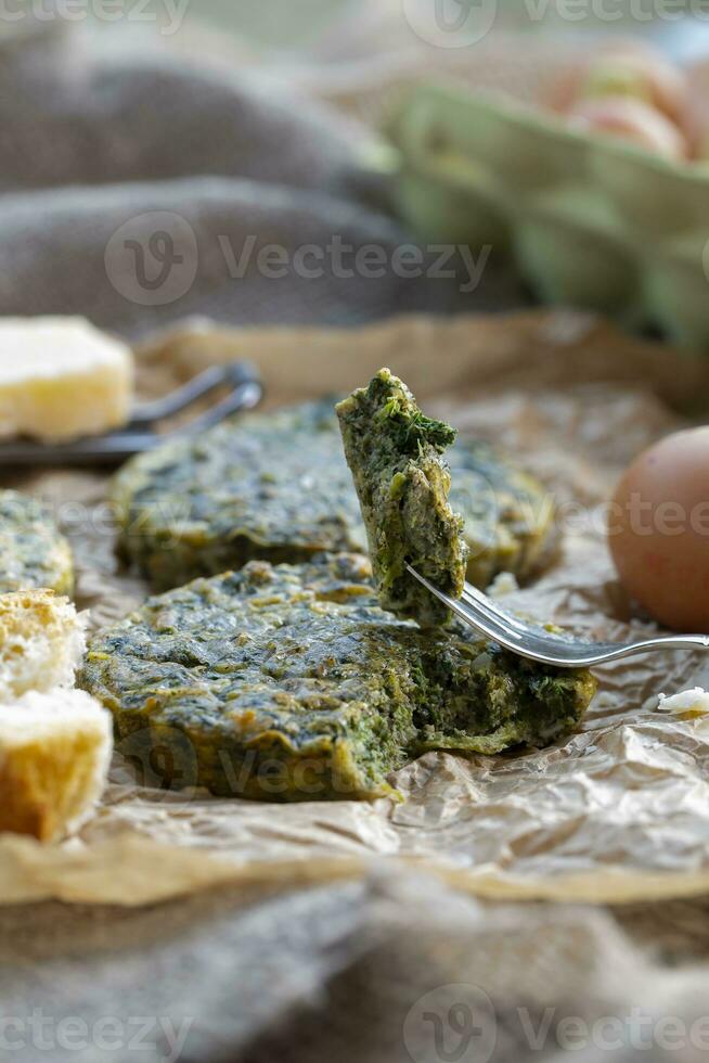 Baked omelette with spinach on a jammed baking paper photo