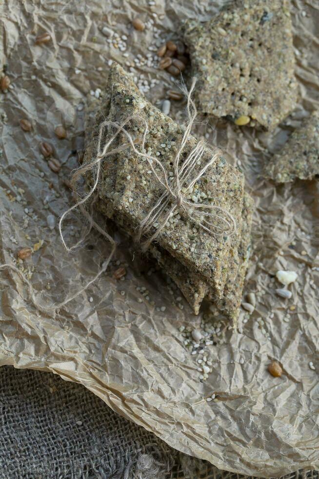 Homemade crisp bread with hemp flour on a jammed baking paper. Closeup photo