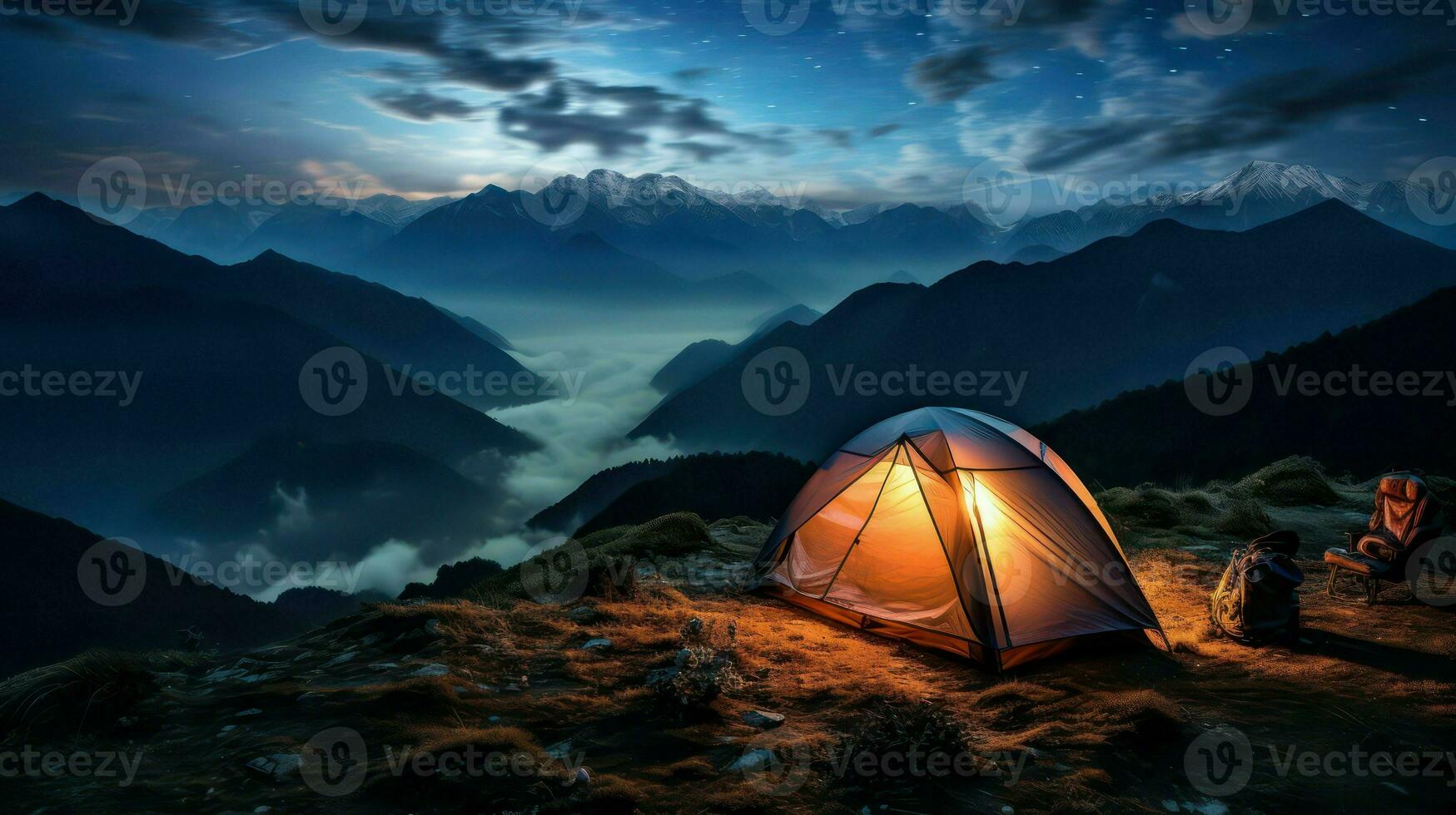Camping in the mountains at night. The tent is on the top of the mountain. photo