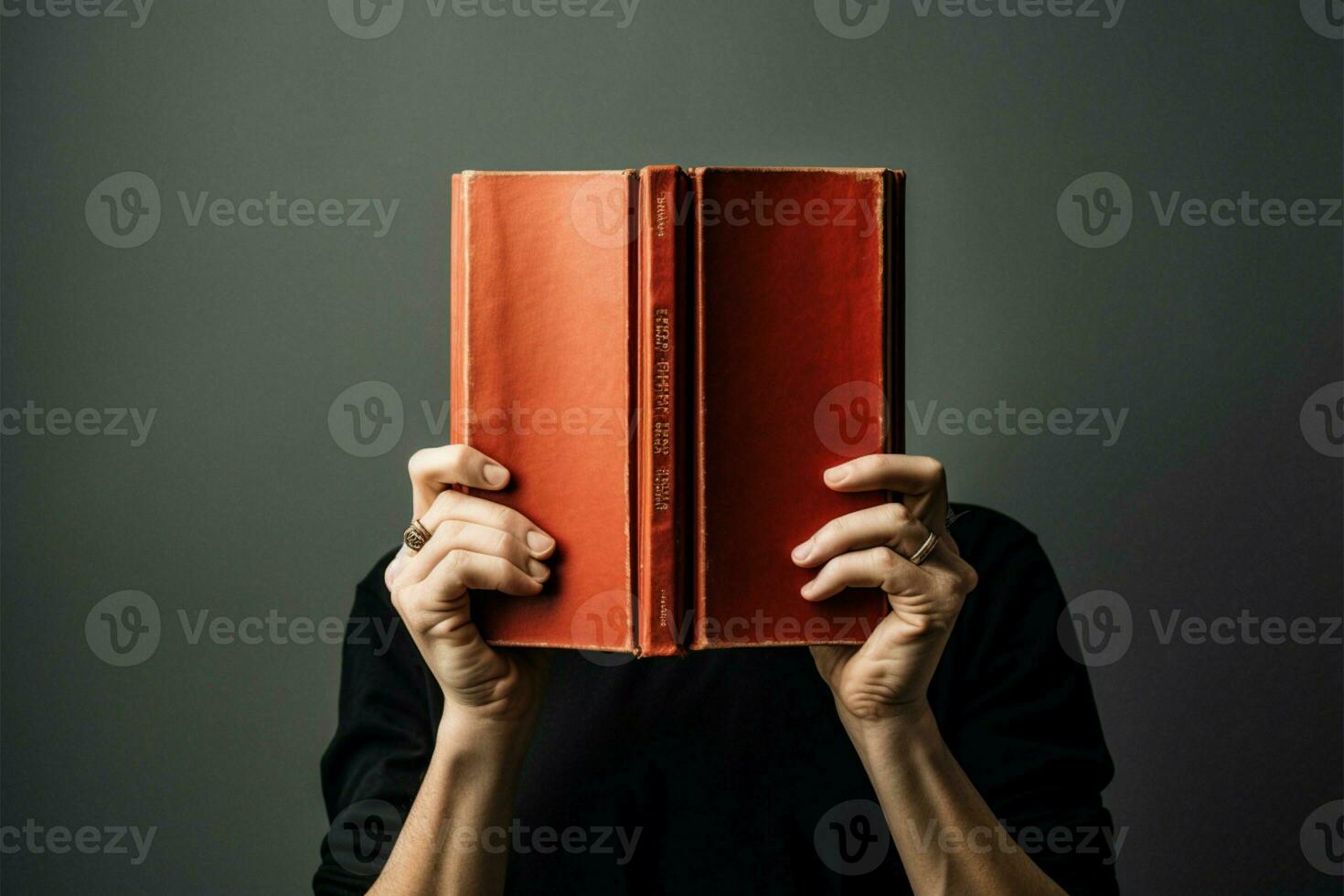 a person holding a book over their face photo