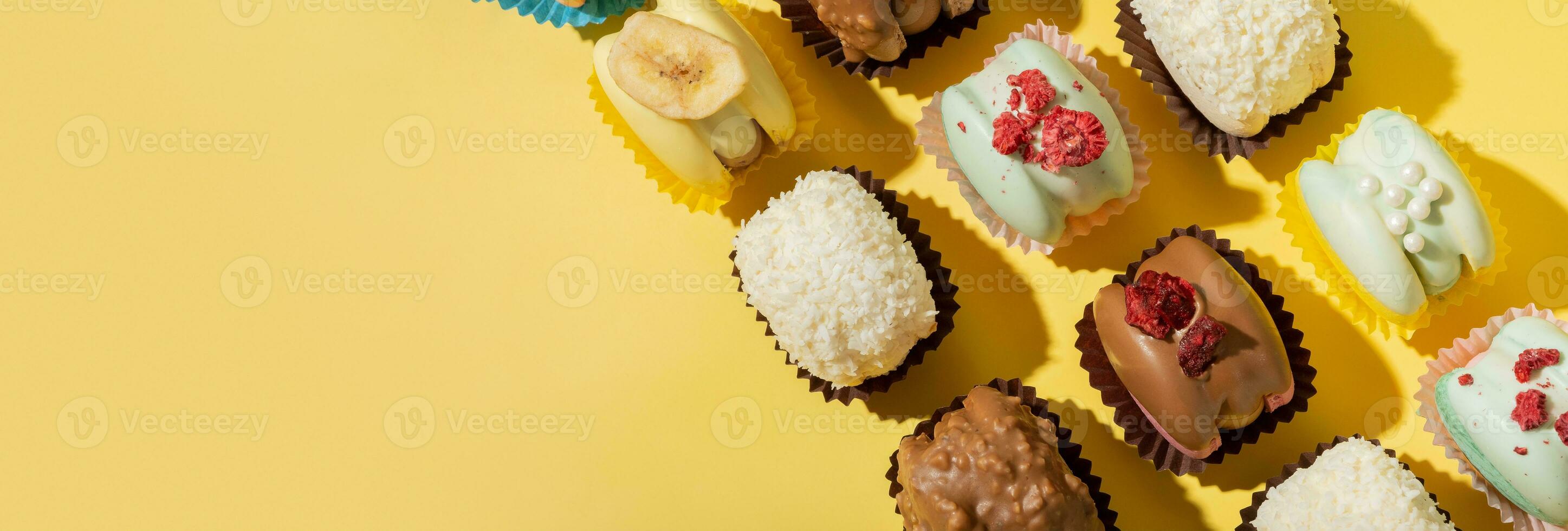 Banner with different macaroons on yellow background top view, flat lay. Copy space. photo
