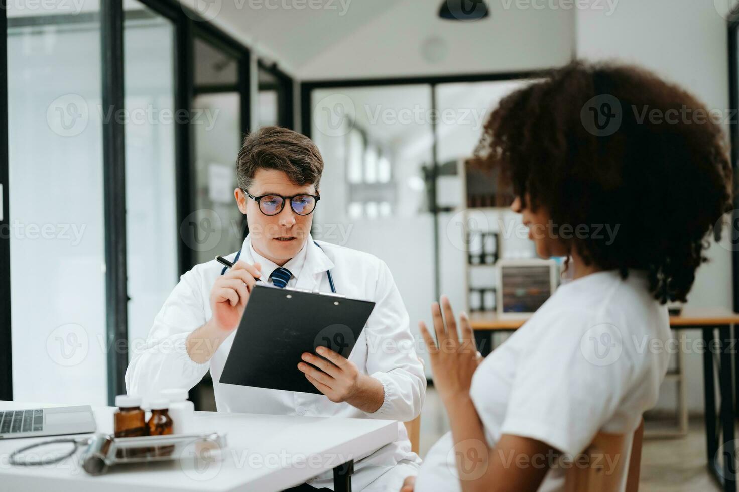 Doctor and patient discussing something while sitting at the table . Medicine and health care concept. photo