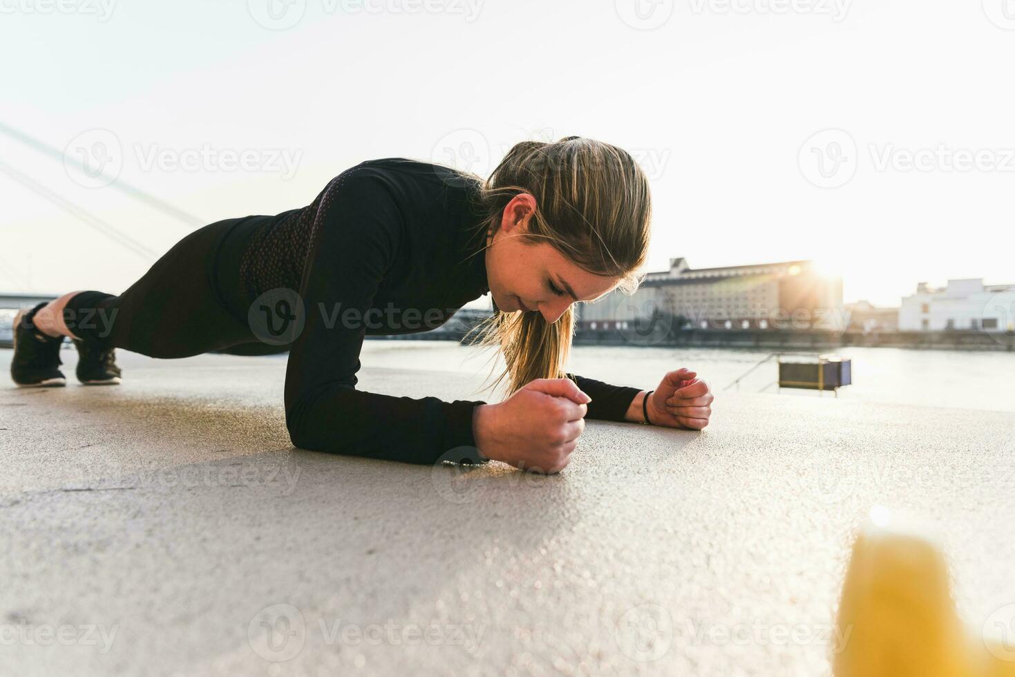 joven mujer hacer ejercicio en el ciudad a puesta de sol foto