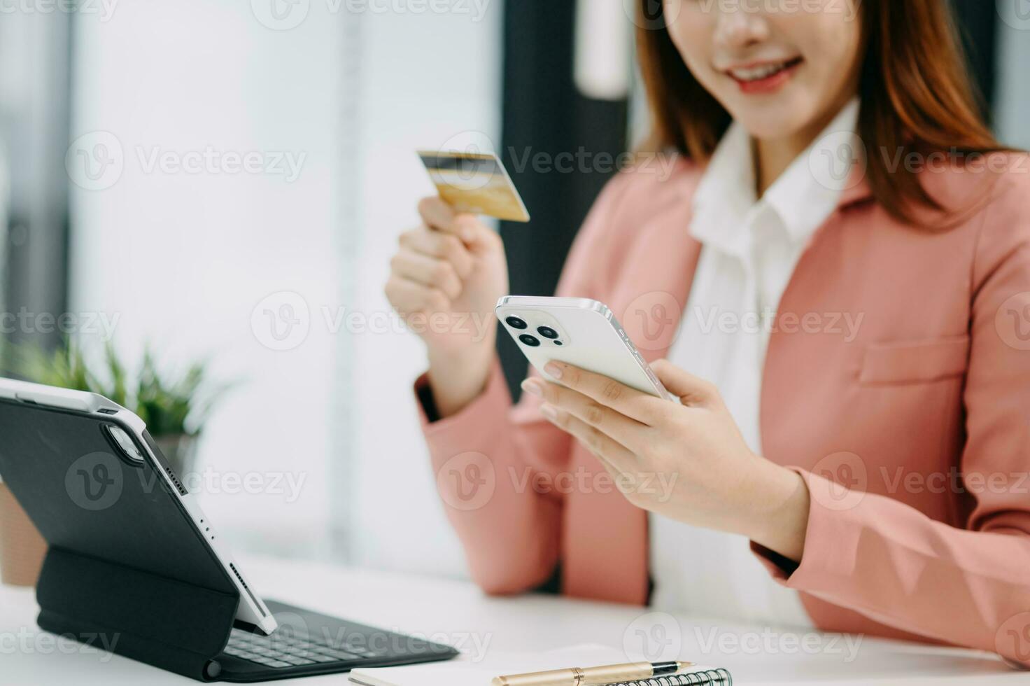Woman using smart phone for mobile payments online shopping, omni channel, sitting on table, virtual icons graphics interface screen photo