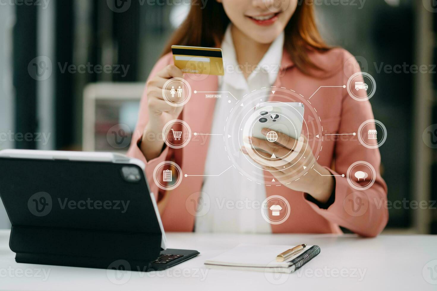 Woman using smart phone for mobile payments online shopping, omni channel, sitting on table, virtual icons graphics interface screen photo