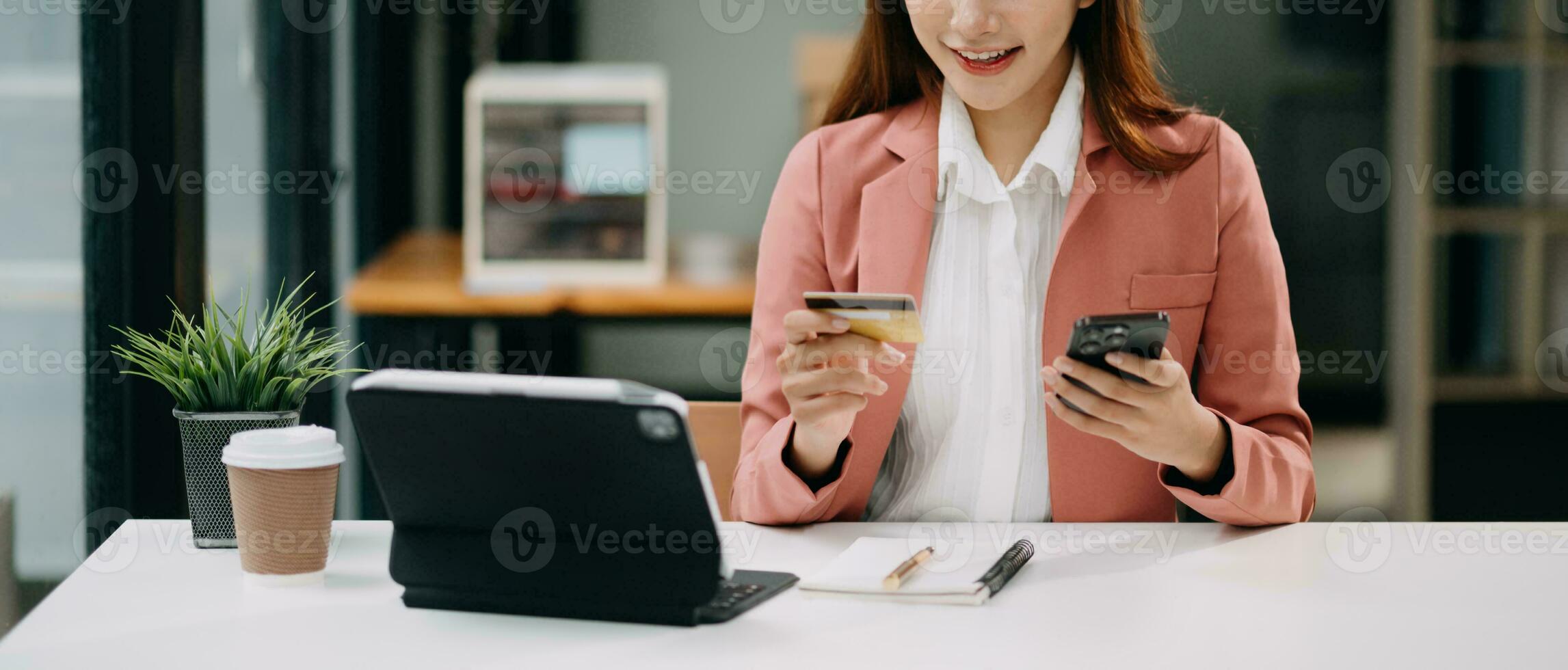 Woman using smart phone for mobile payments online shopping, omni channel, sitting on table, virtual icons graphics interface screen photo