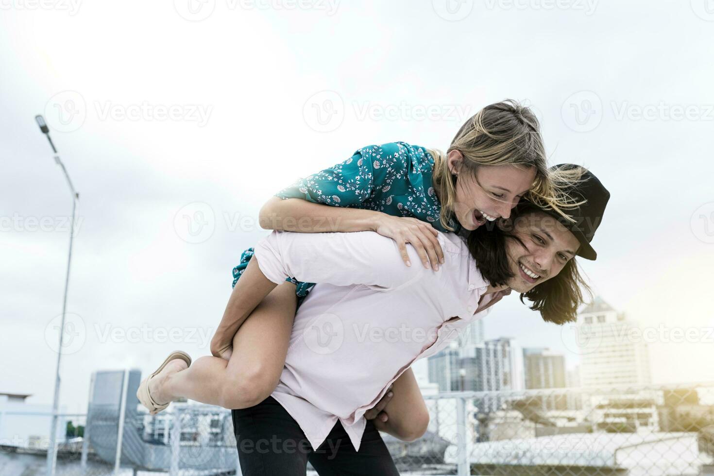 joven cariñoso Pareja teniendo divertido juntos en techo foto