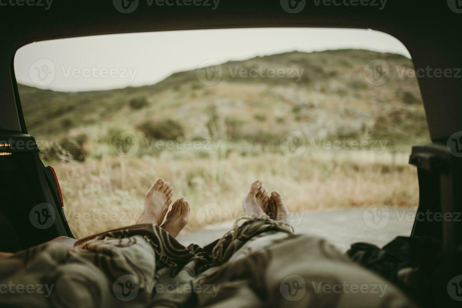 Tired mid adult couple lying in car trunk photo