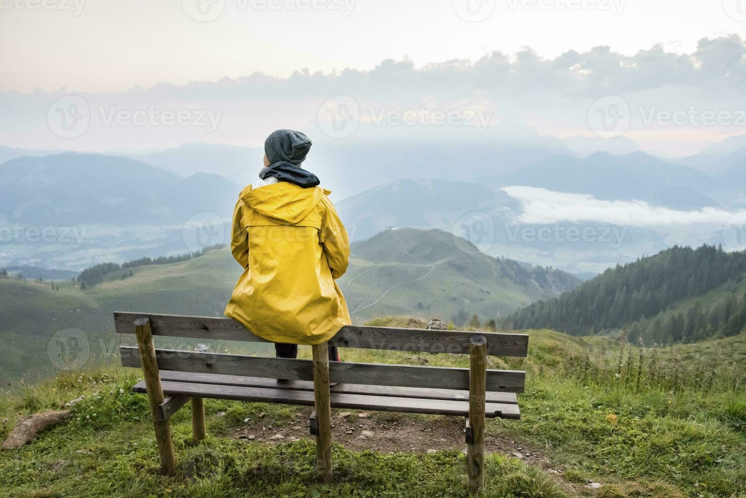 Austria, Tyrol, Fieberbrunn, Wildseeloder, woman sitting on bench with view on mountainscape photo