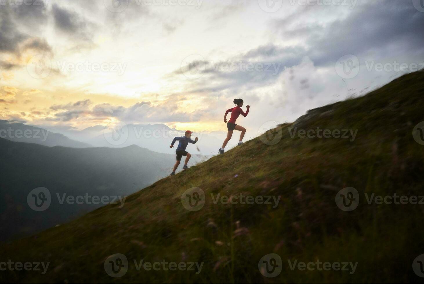 Man and woman running uphill in the mountains photo