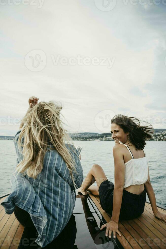 contento hembra amigos en un barco viaje en un lago foto