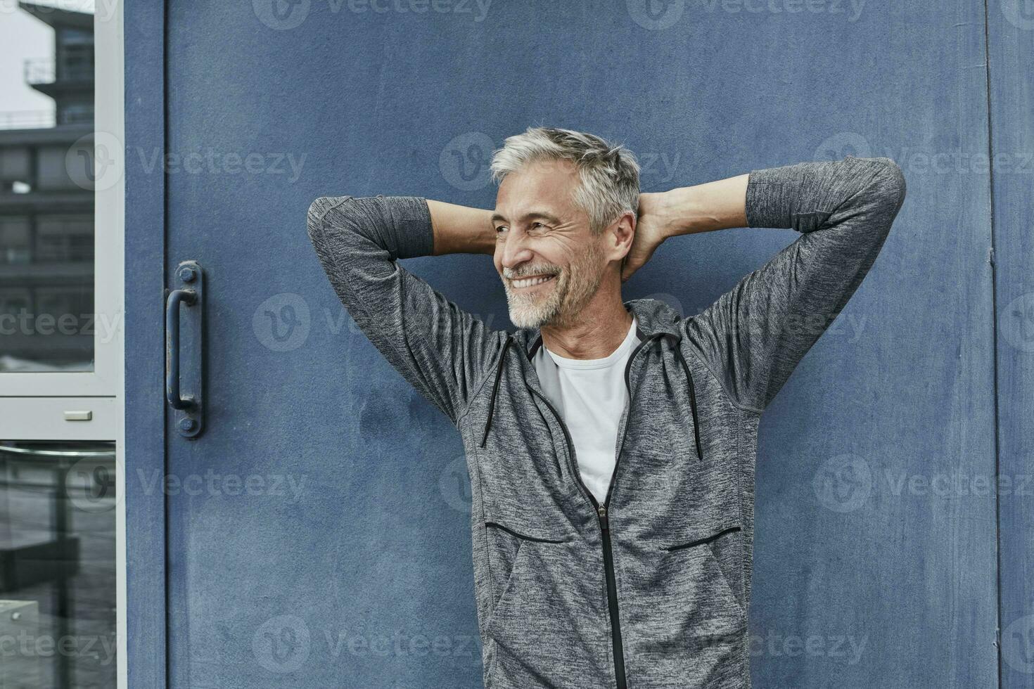 Portrait of laughing mature man in front of gym photo