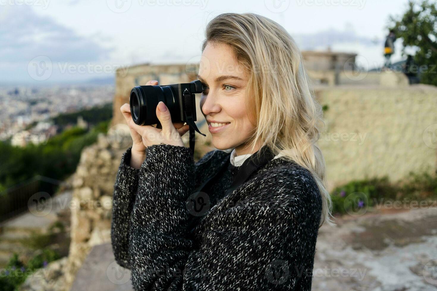 joven mujer tomando imágenes encima el ciudad a amanecer, Barcelona, España foto