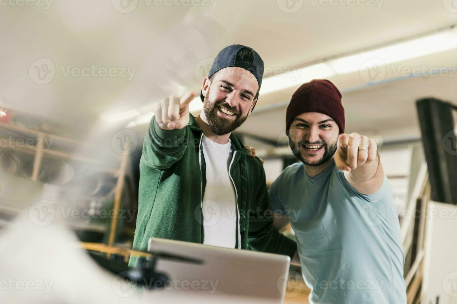 Portrait of two happy young men in workshop photo