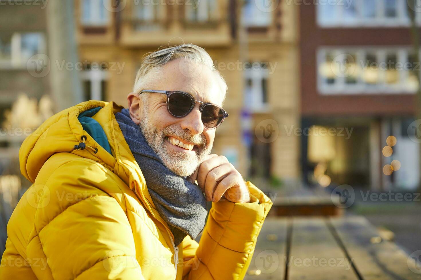 Portrait of smiling mature man wearing sunglasses in the city photo