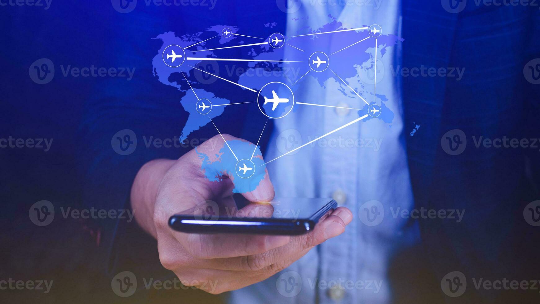 Businessman hand pushing flight booking networking with smart phone, Hand pressing light blue world map with flight routes airplane on blue background, Transportation concept. photo