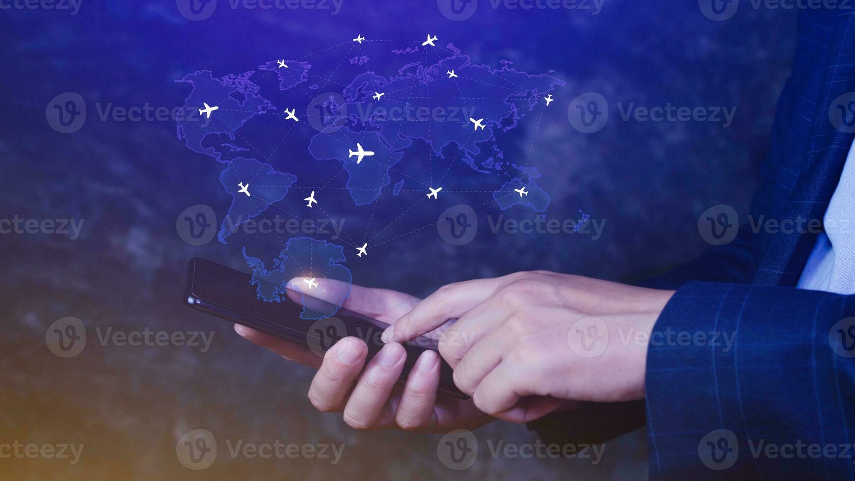 Businessman hand pushing flight booking networking with smart phone, Hand pressing light blue world map with flight routes airplane on blue background, Transportation concept. photo