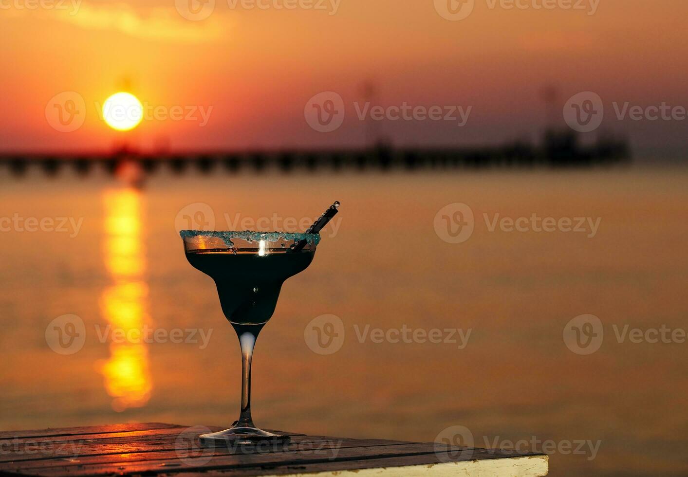 Tropical cocktail overlooking a sunset ocean photo