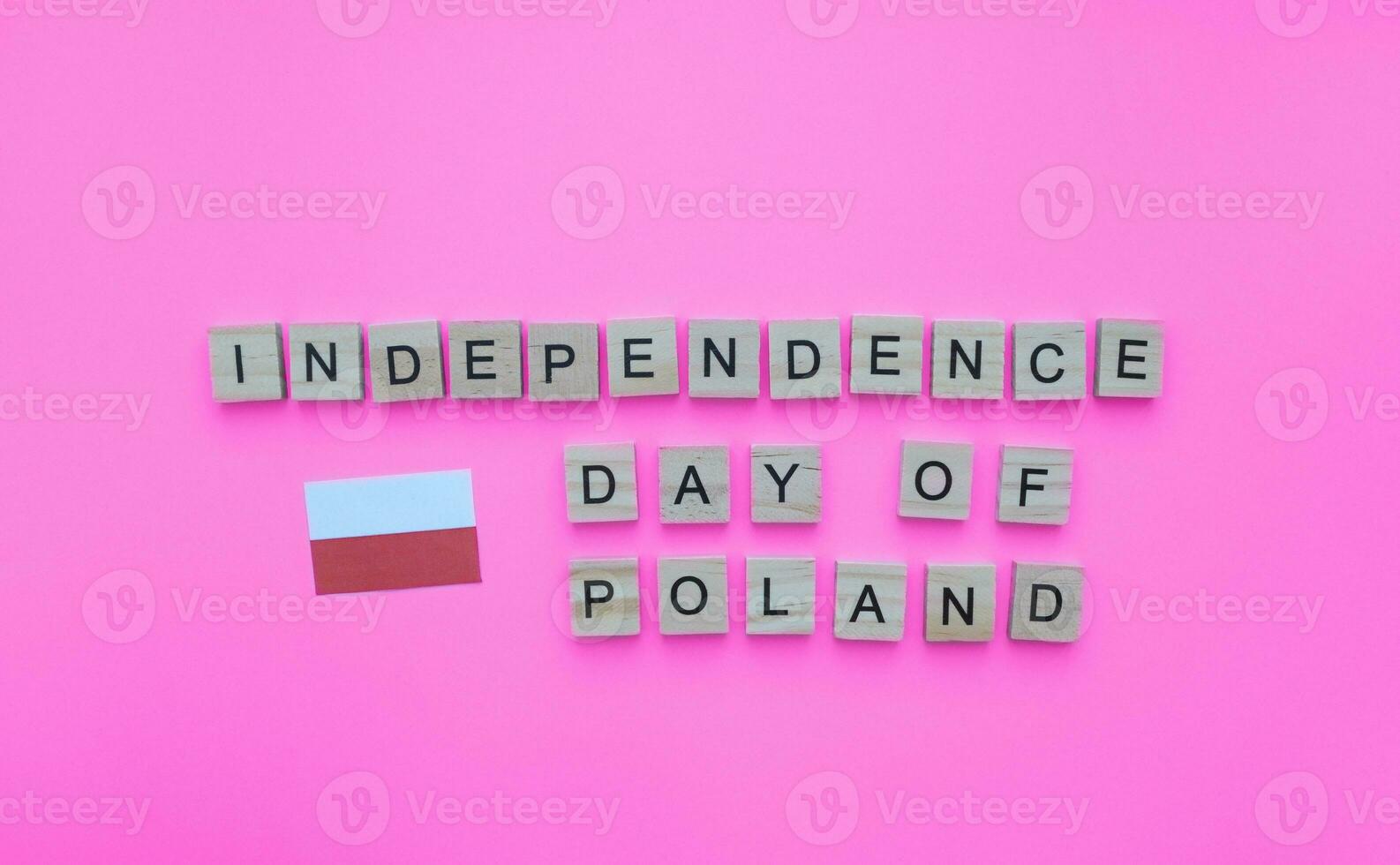November 11, Independence Day of Poland, the flag of Poland, a minimalistic banner with the inscription in wooden letters on a pink background photo