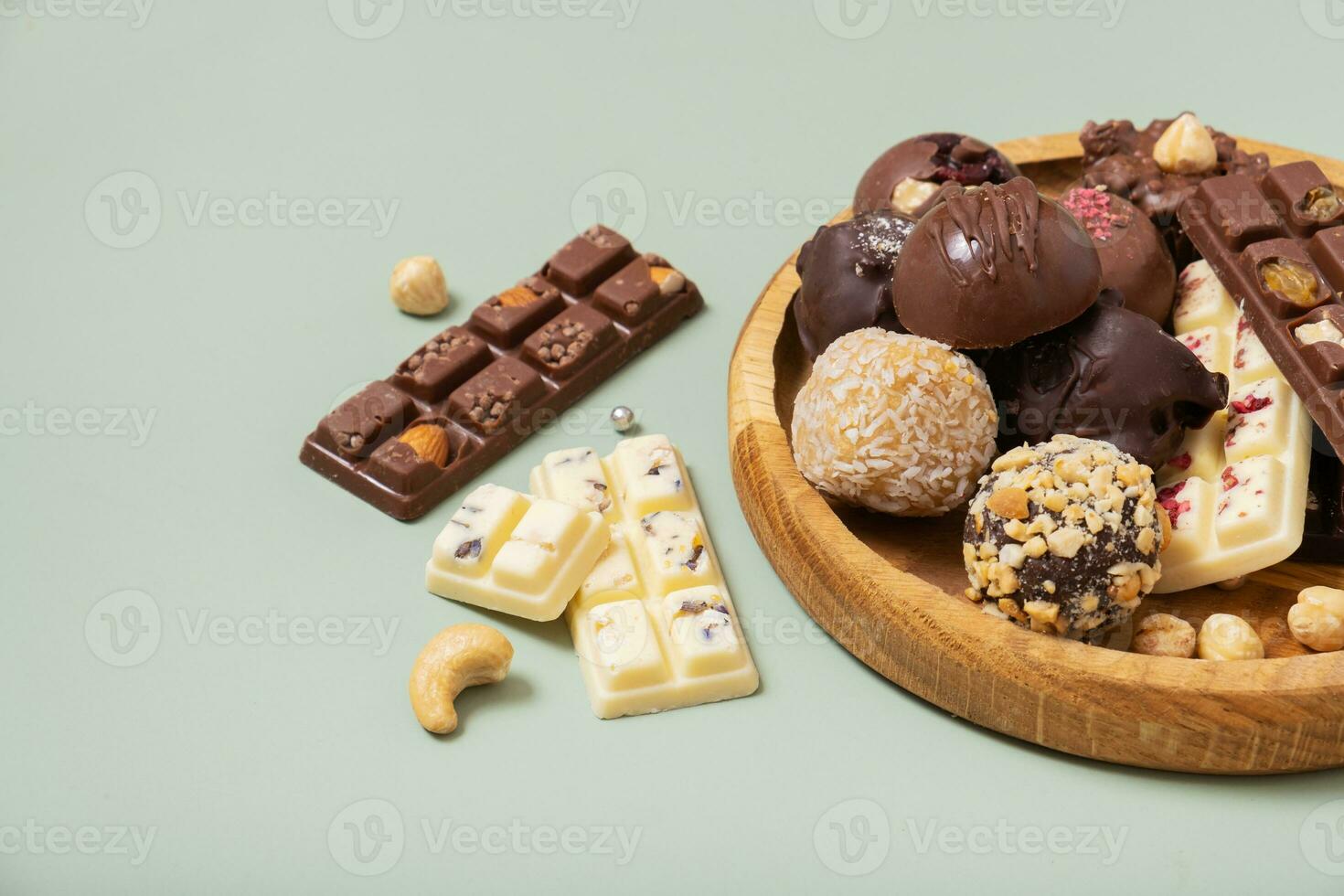 Healthy craft natural mini chocolates top view. Sweet food, healthy dessert on green background. photo